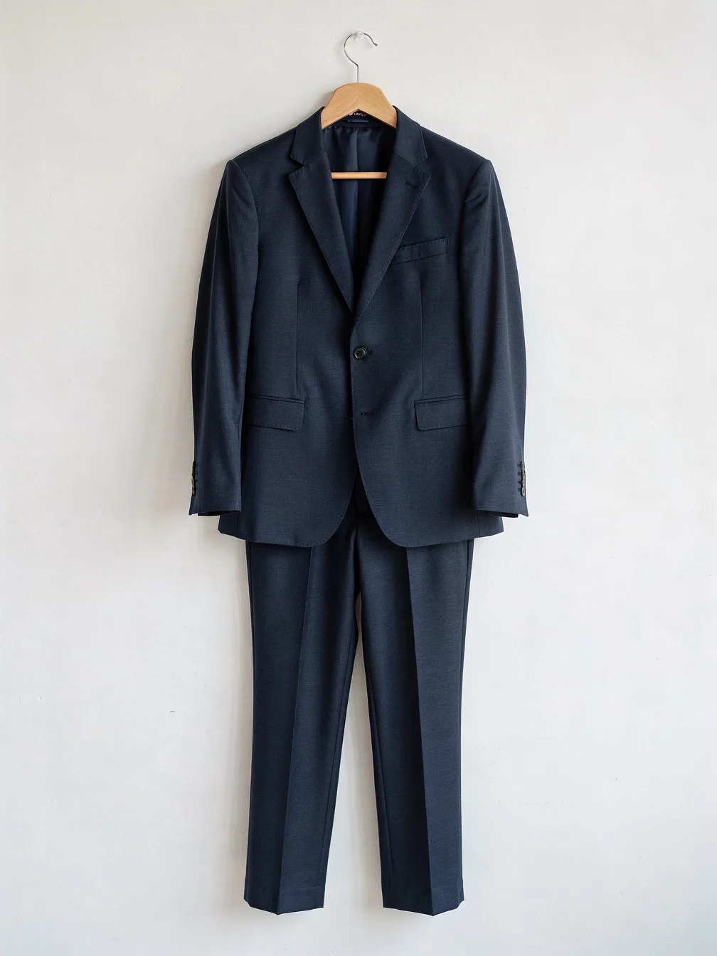 Outfit try-on input: a navy blue two-piece suit on a hanger
